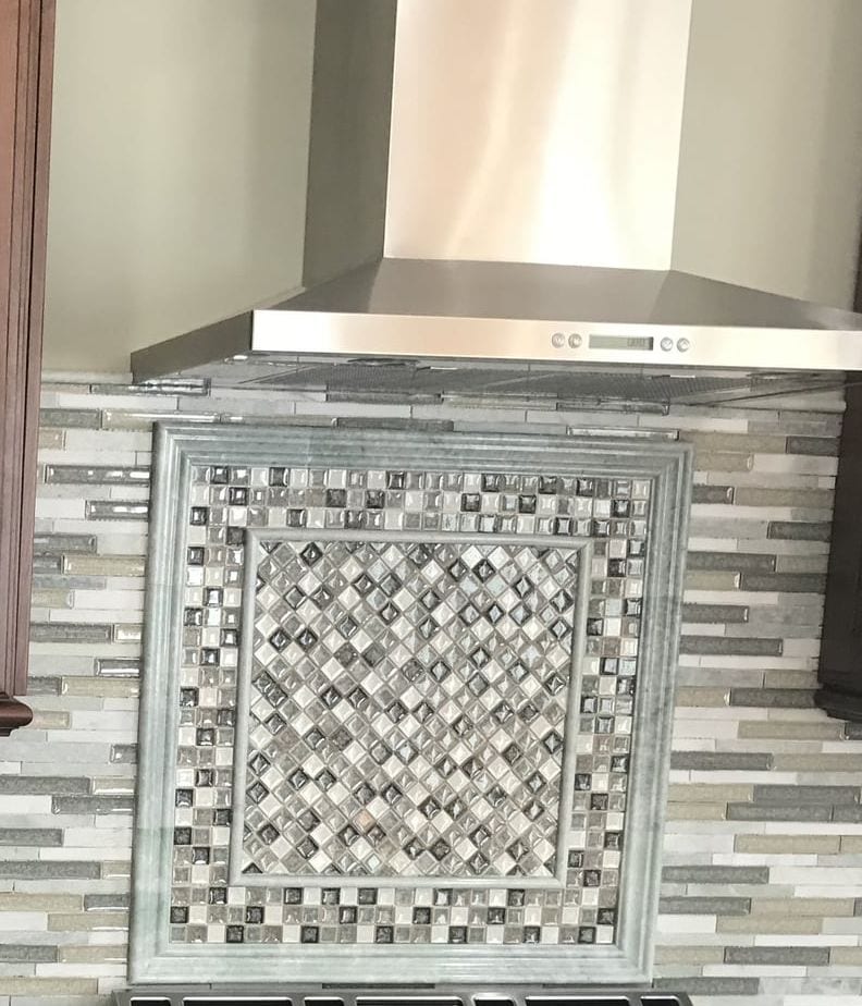 Mosaic tile backsplash medallion under a stainless range hood