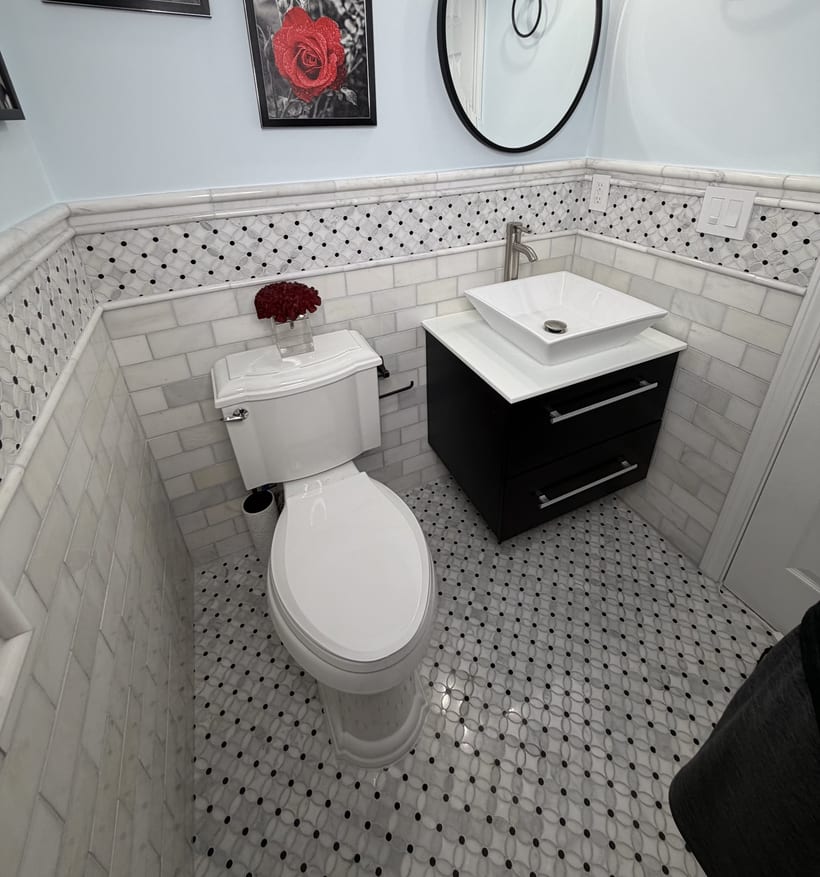 Luxury bathroom with floating black vanity and decorative marble mosaic tile