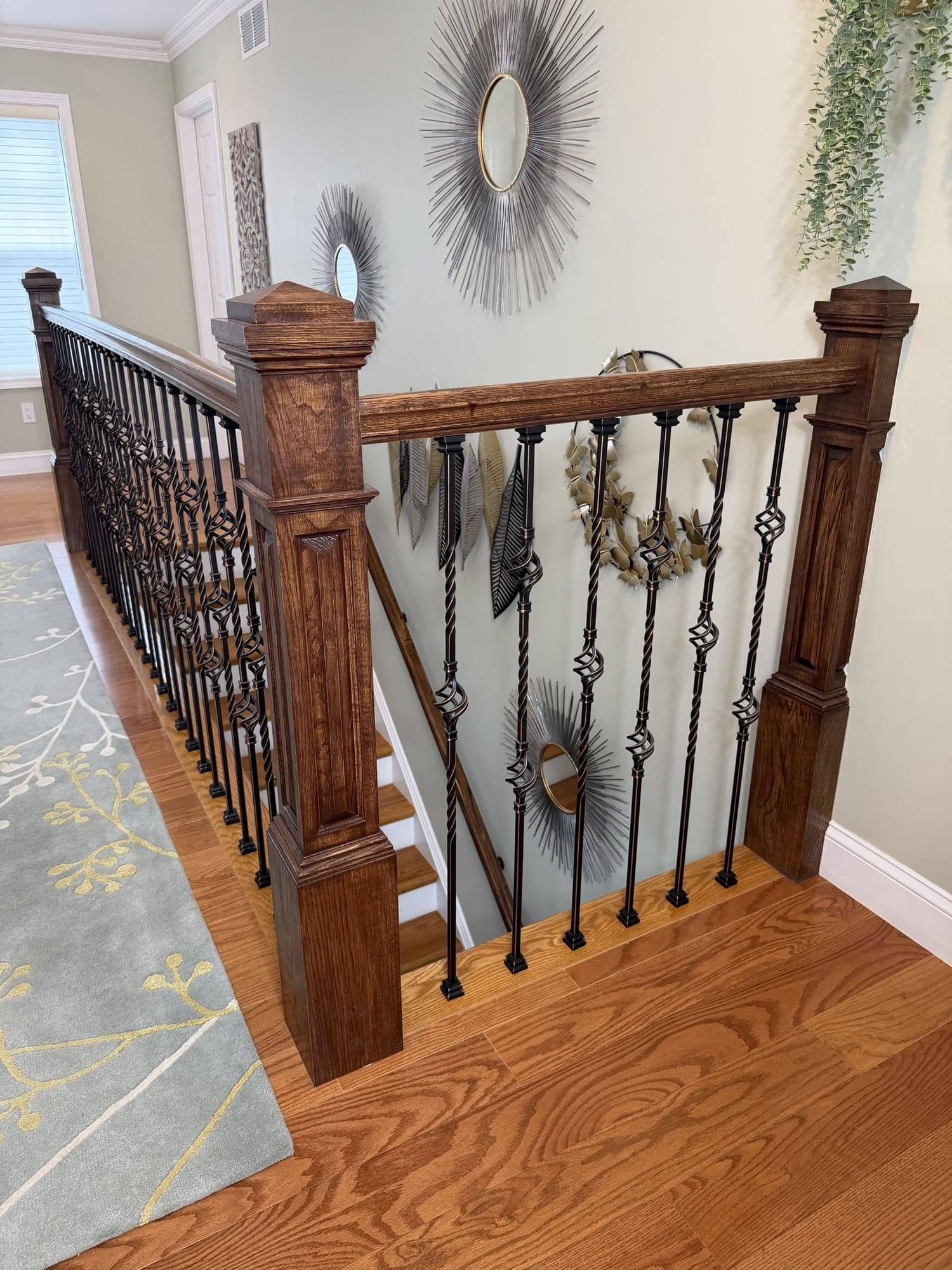 Upstairs landing with stained oak railing, wrought iron balusters and hardwood floors